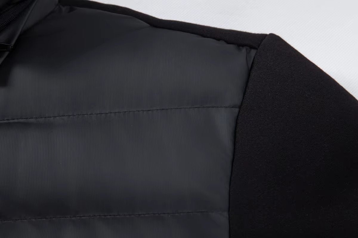 Shoulder seam showing quilted panel meeting jersey sleeve on black jacket