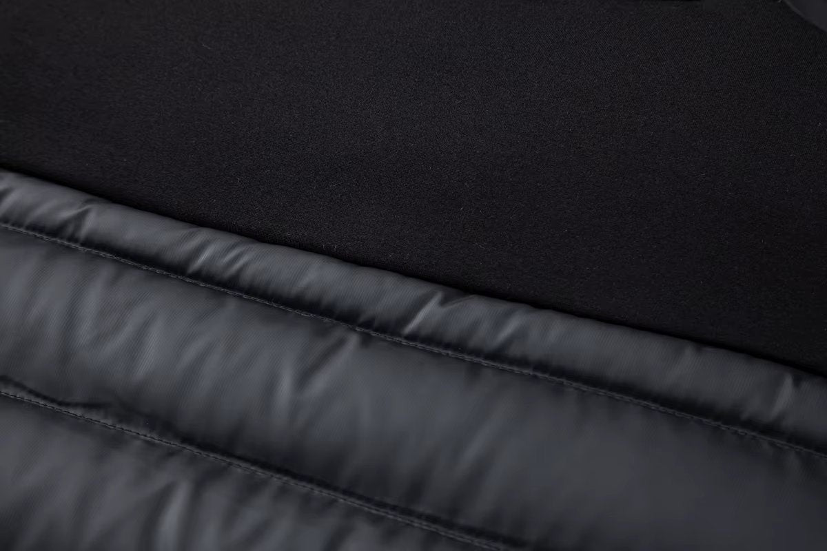 Jersey sleeve cuff detail against quilted body on black hybrid jacket
