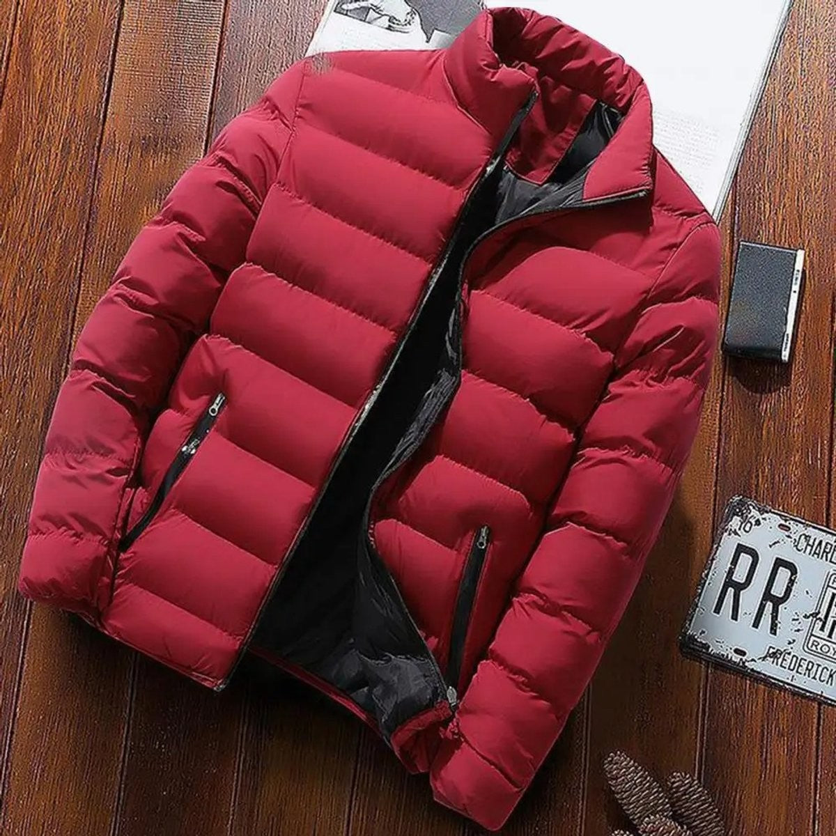Burgundy quilted puffer jacket laid flat on wooden surface