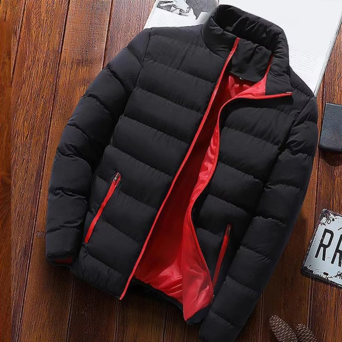 Black puffer jacket laid flat with red inner lining exposed