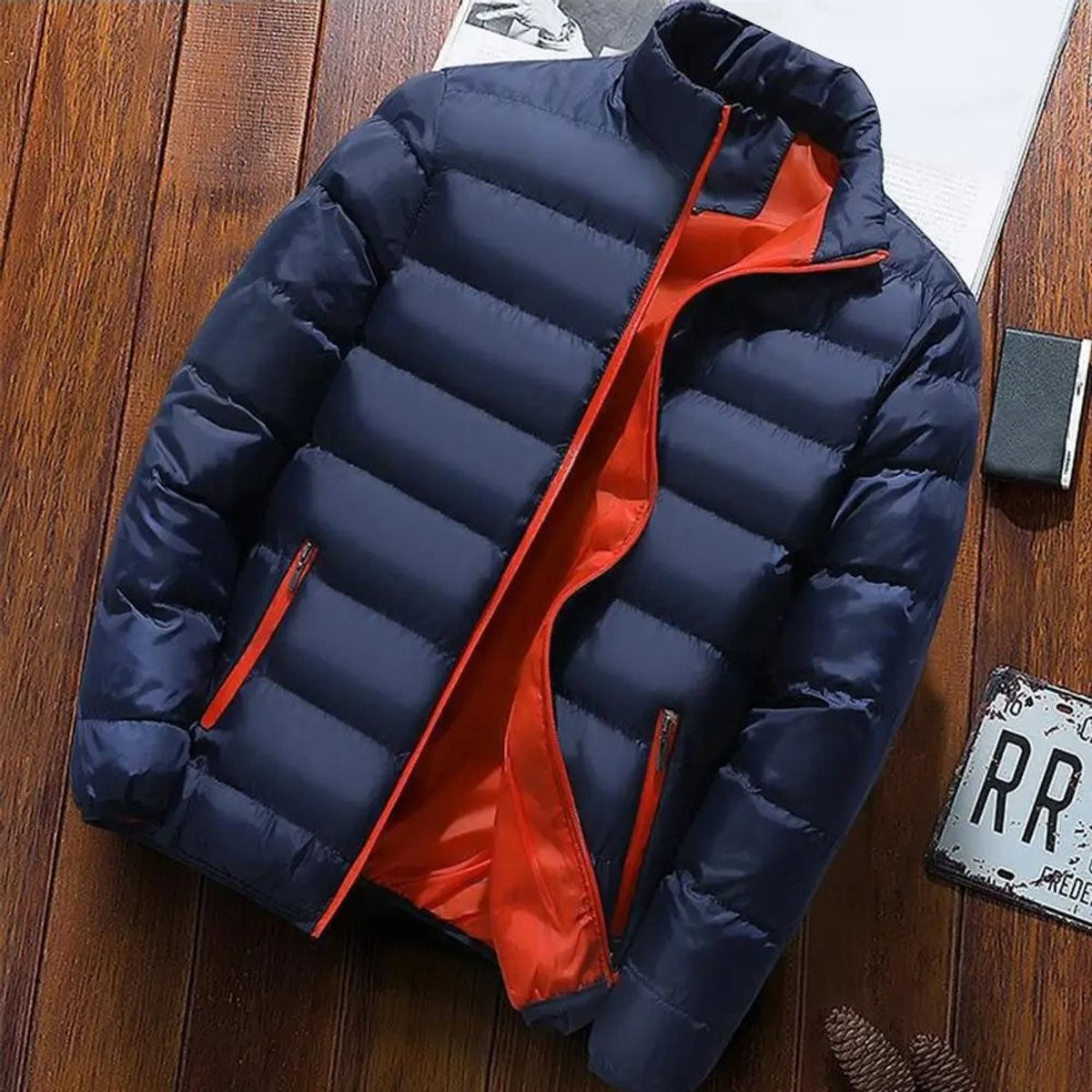 Navy puffer jacket laid flat showing orange contrast lining