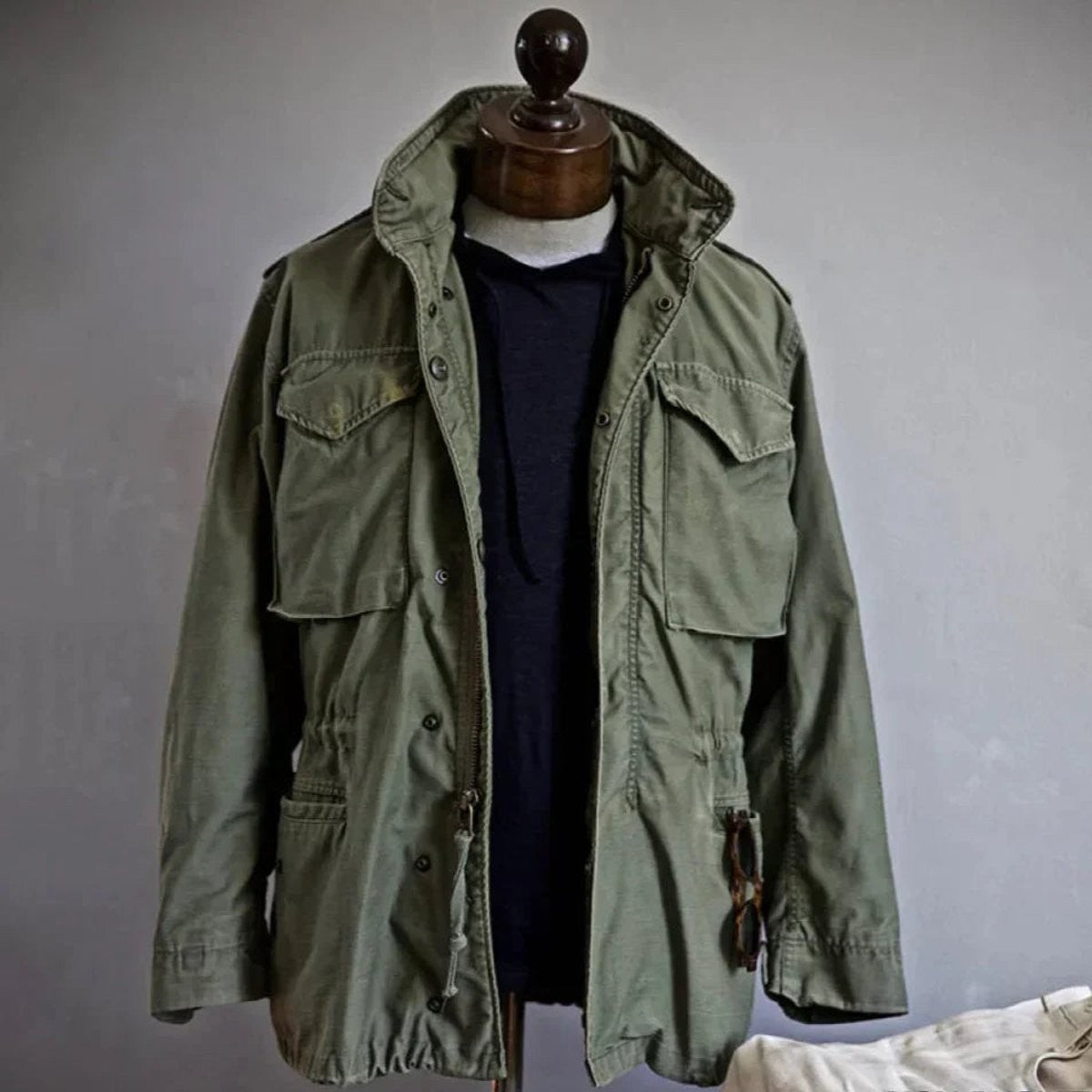 Vintage-style khaki field jacket with drawstring waist and stand collar