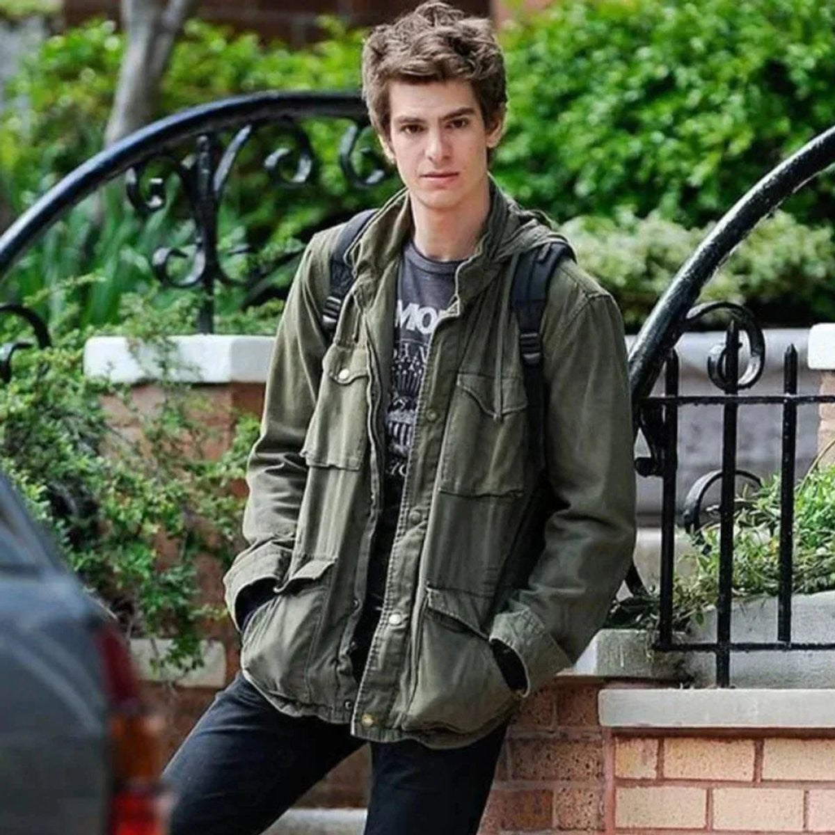 Model wearing olive field jacket layered over a Ramones graphic tee