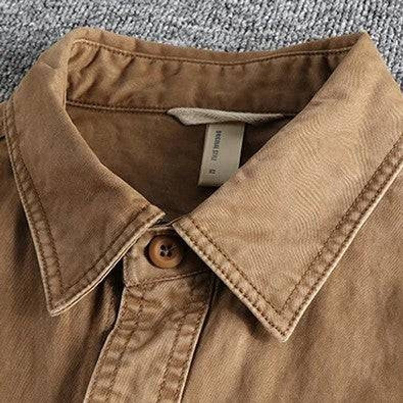 Close-up of pointed collar and button fastening on tan field shirt