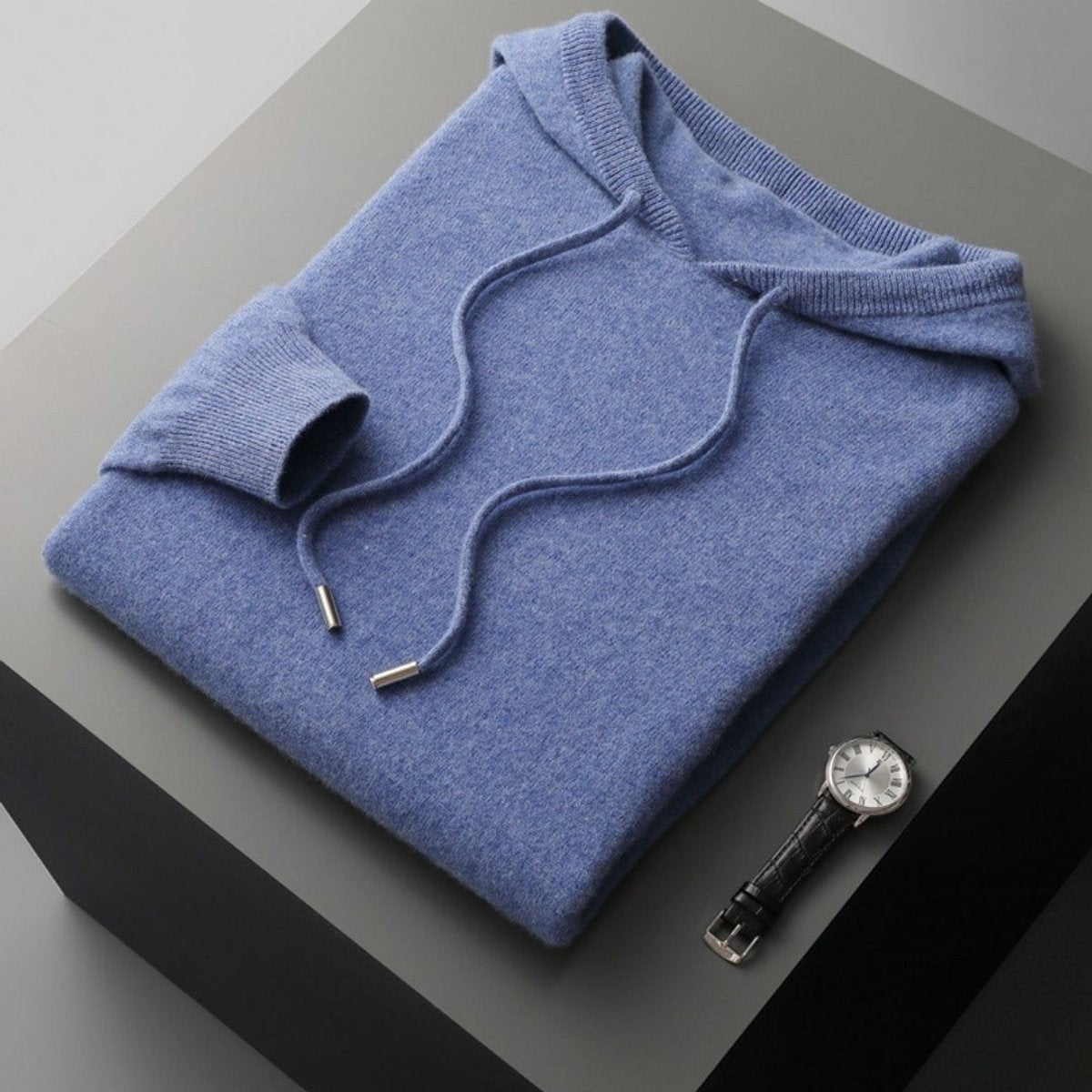 Folded slate blue cashmere hoodie jumper with ribbed cuffs and hood