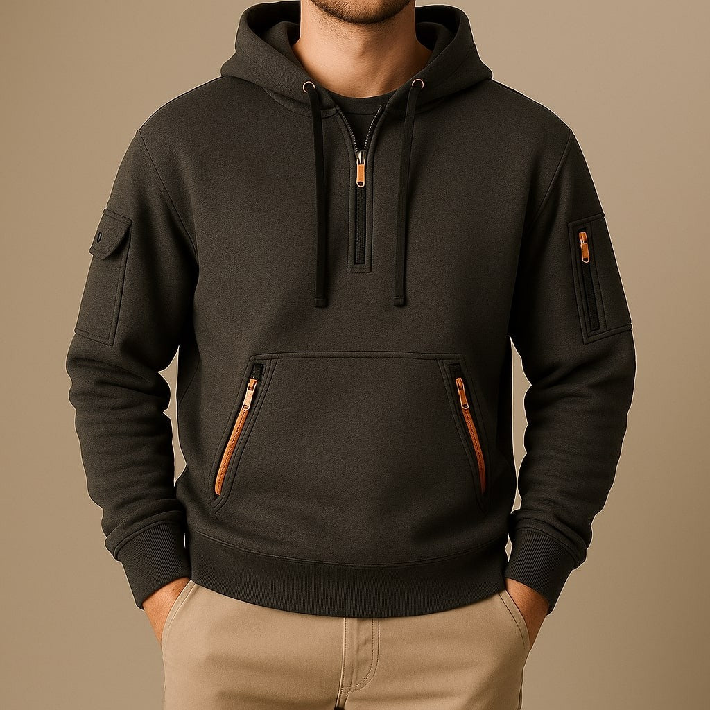 Man wearing charcoal half-zip fleece hoodie with orange zip accents
