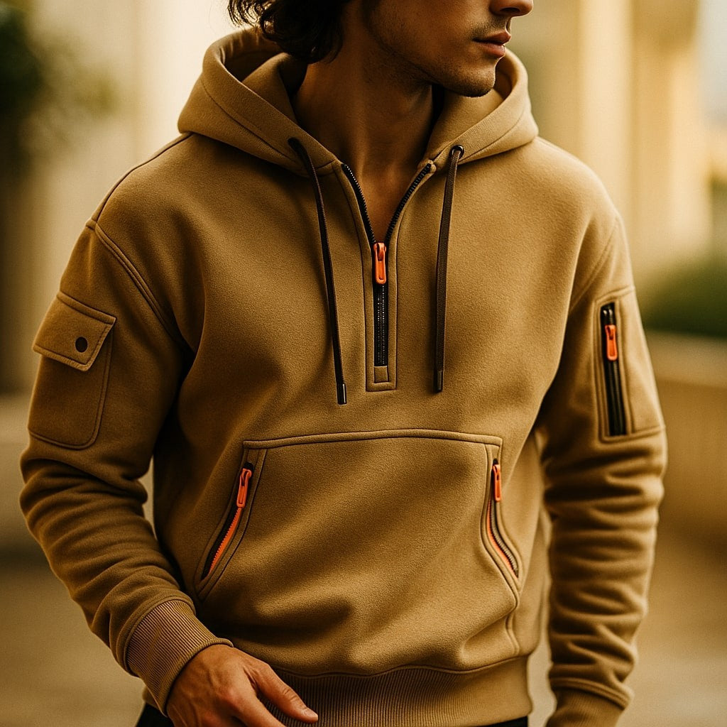 Close-up of camel half-zip hoodie worn outdoors with zip pocket detail