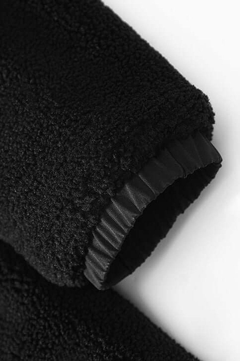 Detail shot of black sherpa fleece sleeve with elasticated cuff