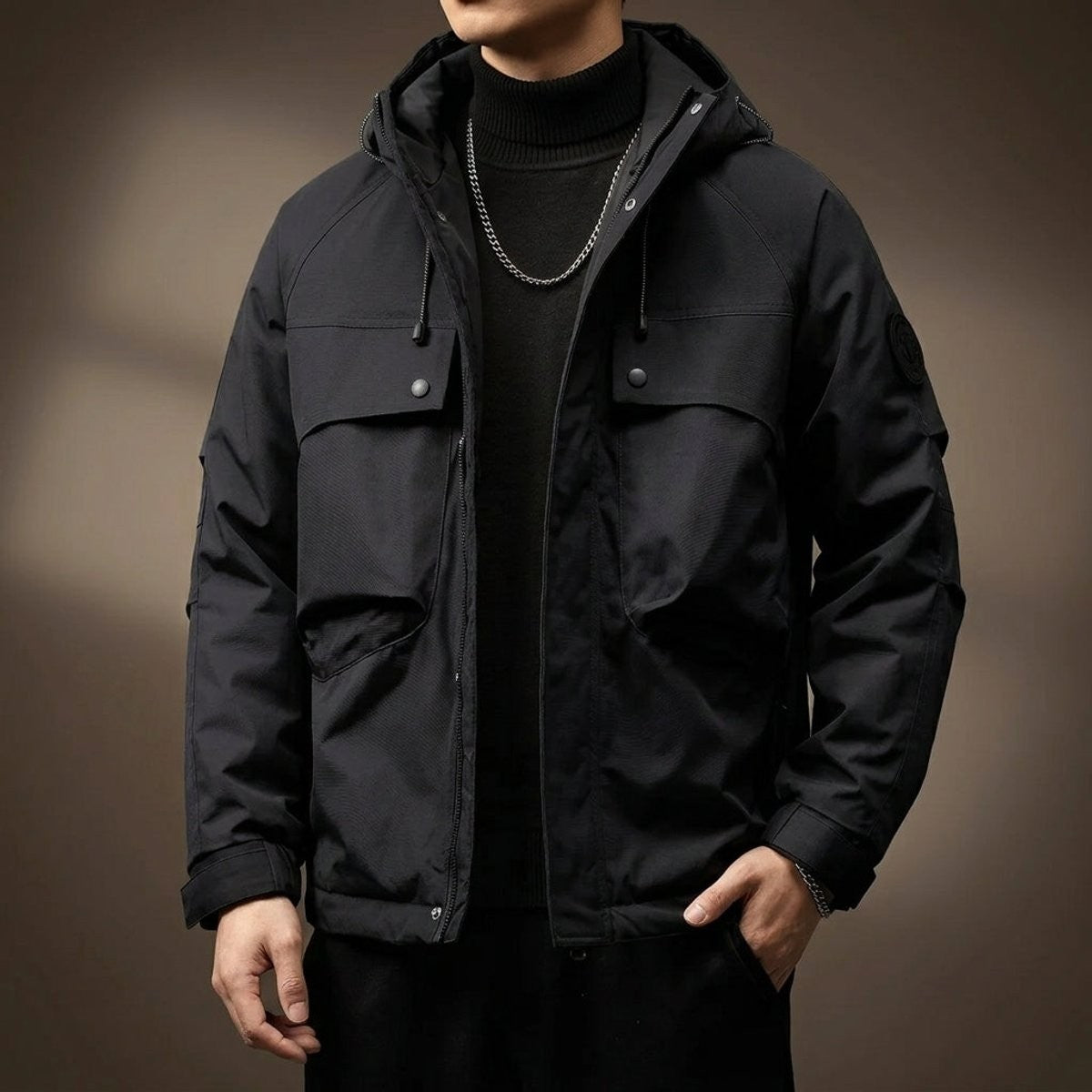 Black hooded cargo jacket showing snap-button pockets and sleeve badge