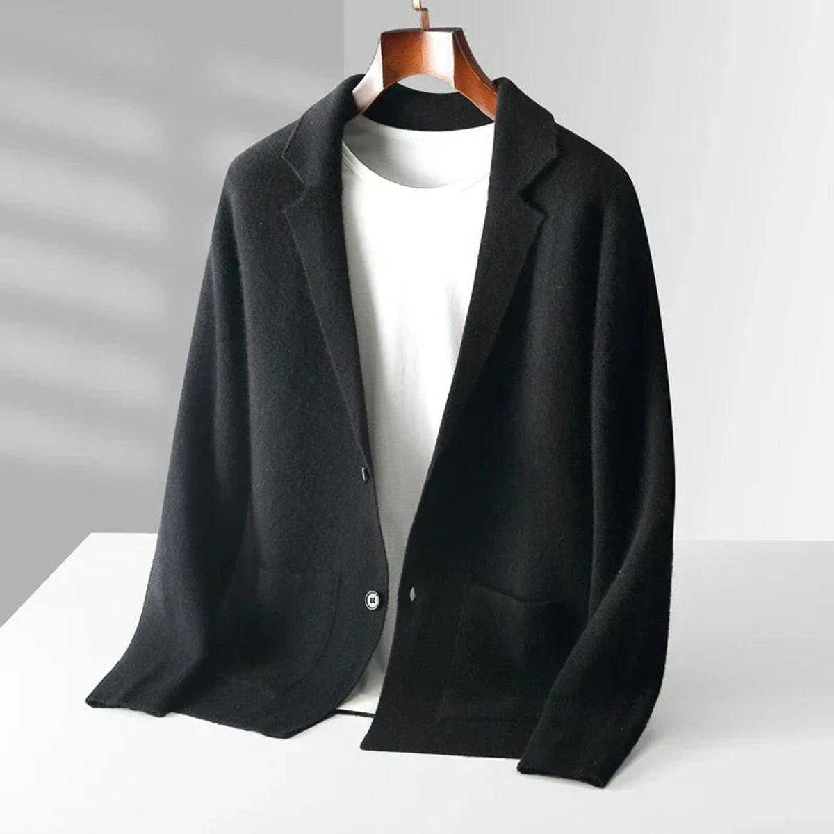 Black knitted notch-lapel blazer cardigan with button fastening on hanger