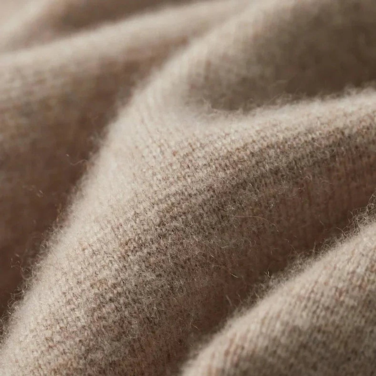 Macro shot of soft beige cashmere knit fabric texture on blazer cardigan