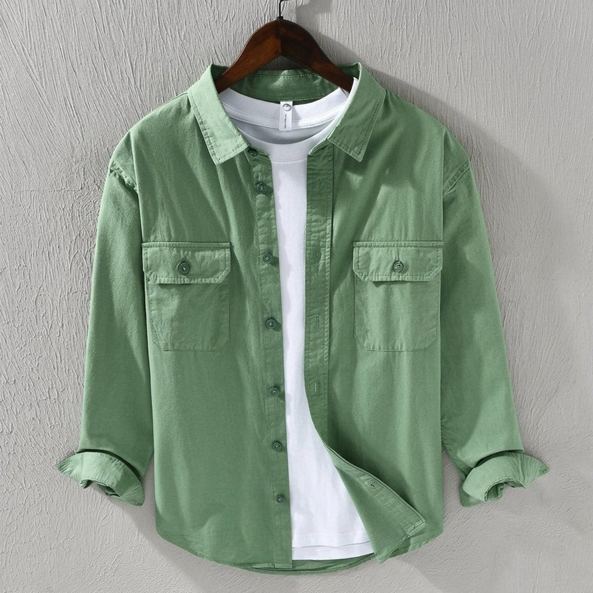 Sage green cotton overshirt with twin chest pockets, worn over white tee