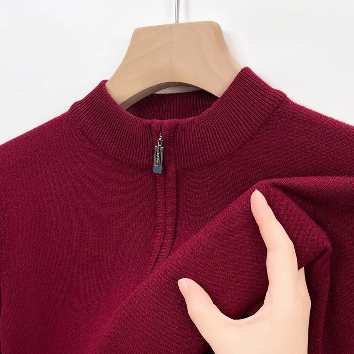 Burgundy knitted jumper collar close-up with zip fastening detail