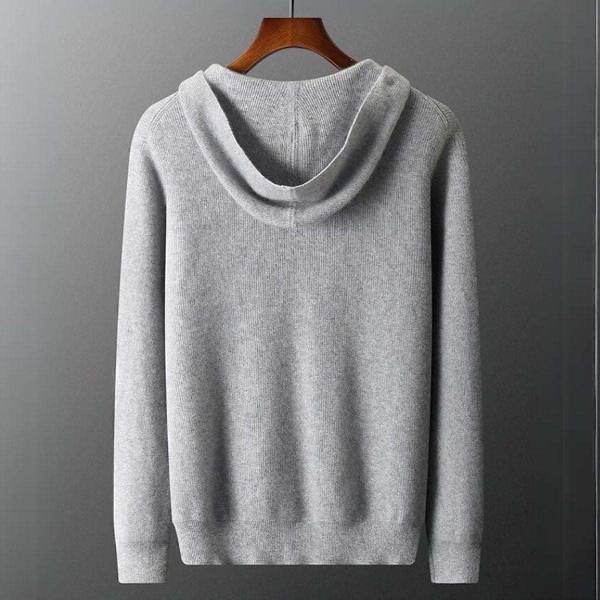 Back view of grey knitted zip hoodie showing hood seams and ribbed cuffs