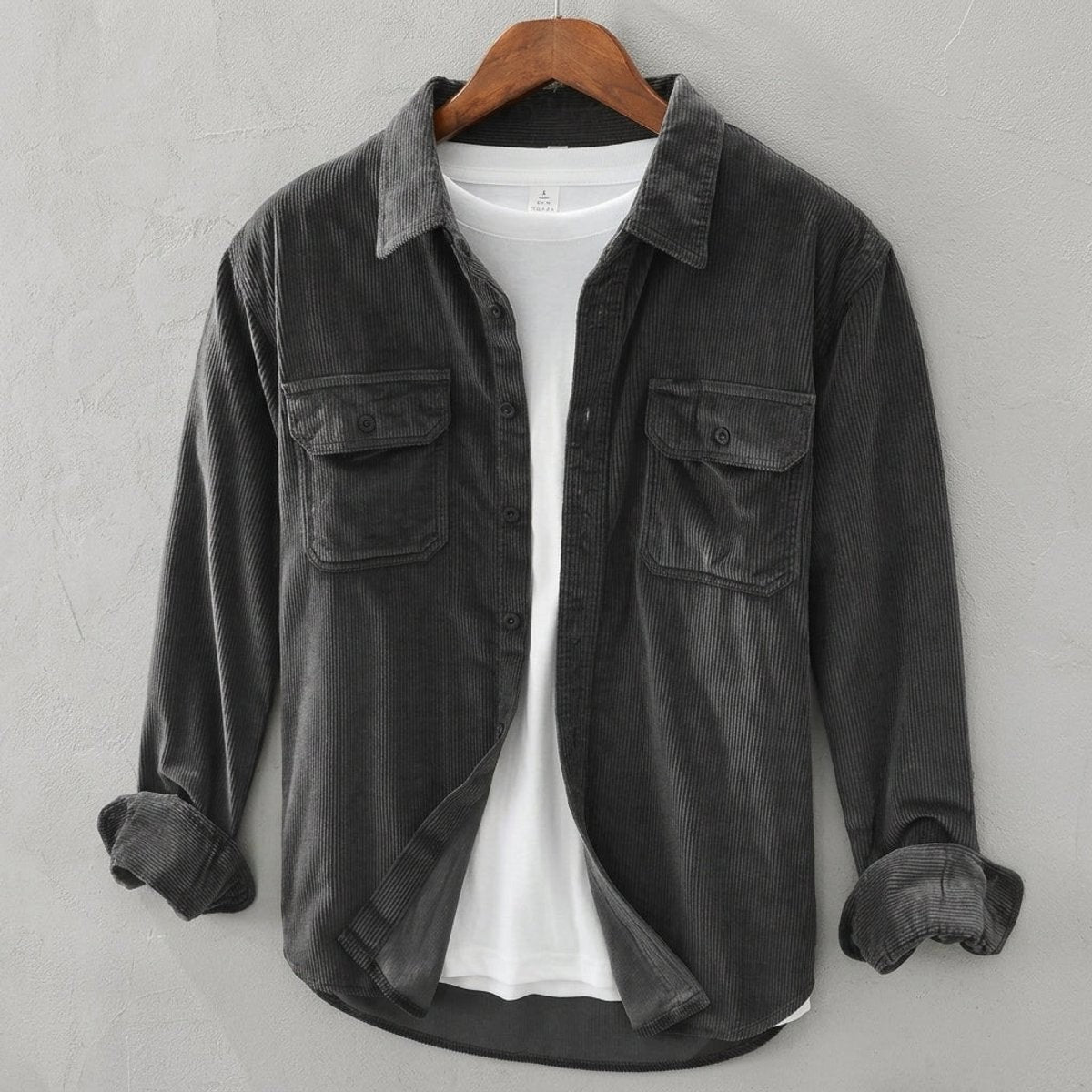 Charcoal grey corduroy overshirt with dual chest pockets, buttoned on hanger
