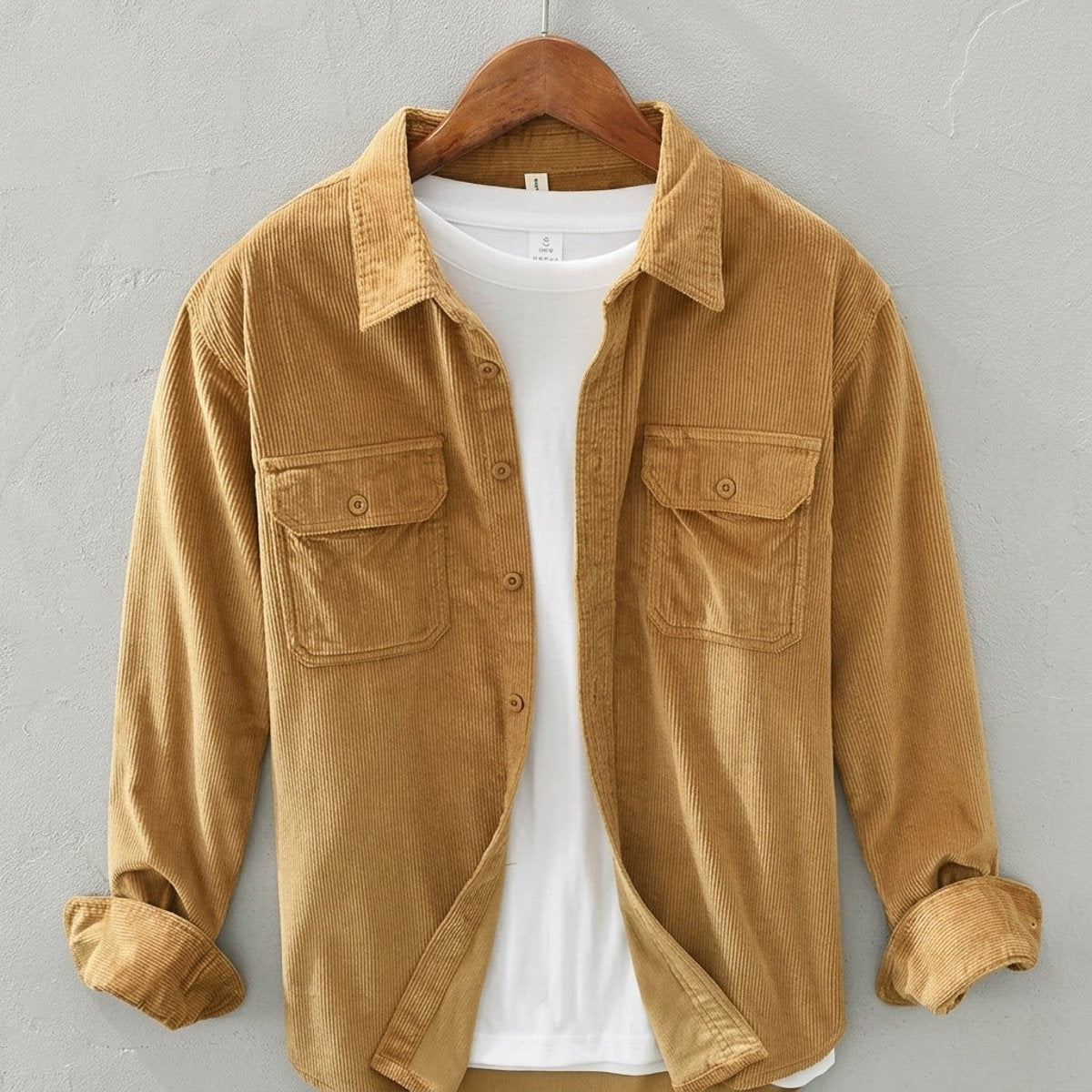 Mustard corduroy overshirt with chest pockets, hanging open over white tee