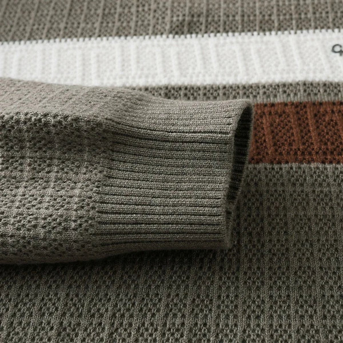 Close-up of ribbed cuff and striped knit texture on khaki jumper
