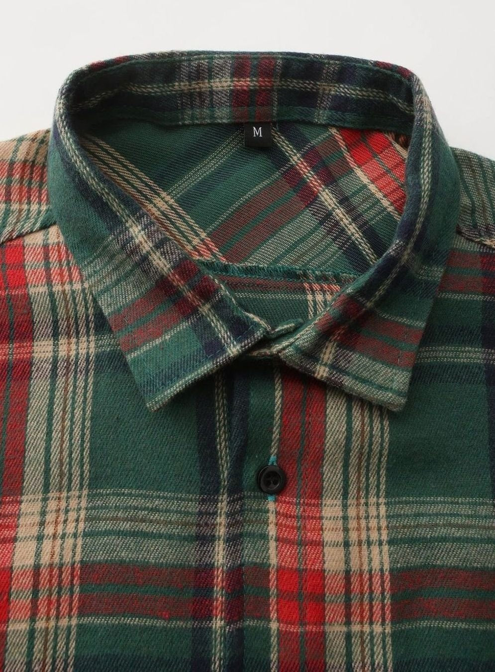 Close-up of flannel shirt collar and buttoned neckline in green plaid