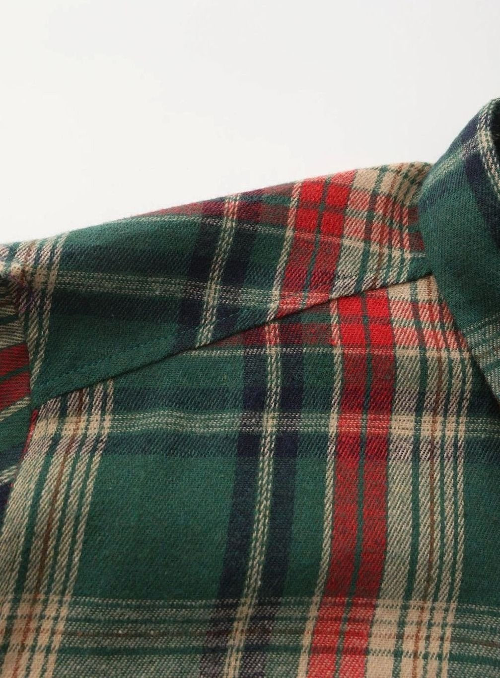 Detailed weave close-up of green and red checked flannel fabric