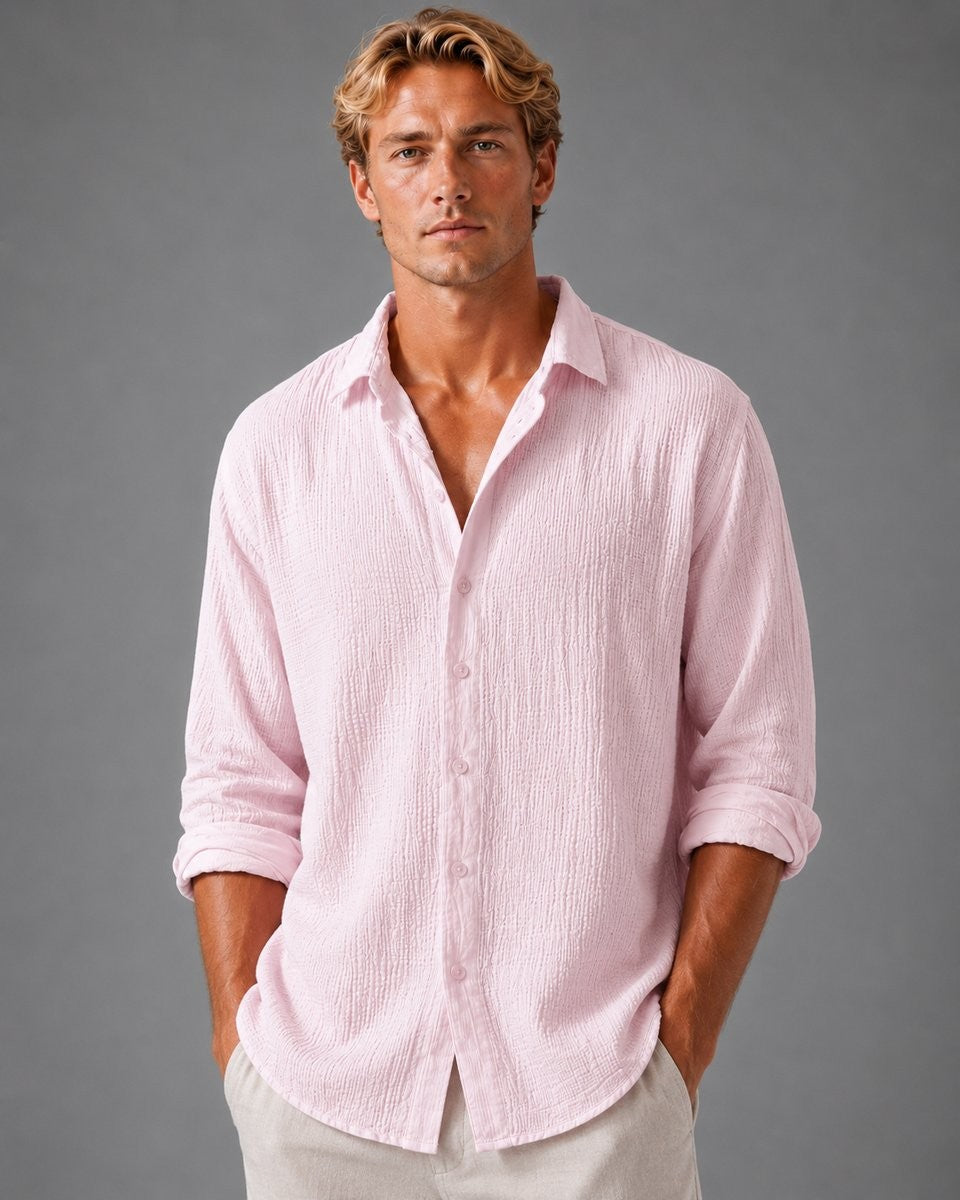 Man wearing pink textured long-sleeve shirt with open collar and rolled cuffs