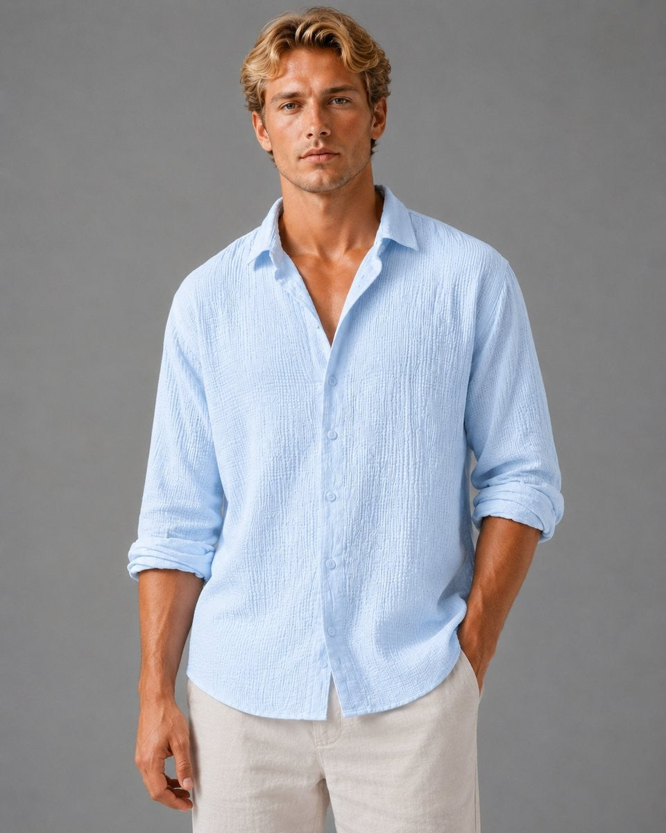 Pale blue textured long-sleeve shirt worn open-necked with rolled sleeves