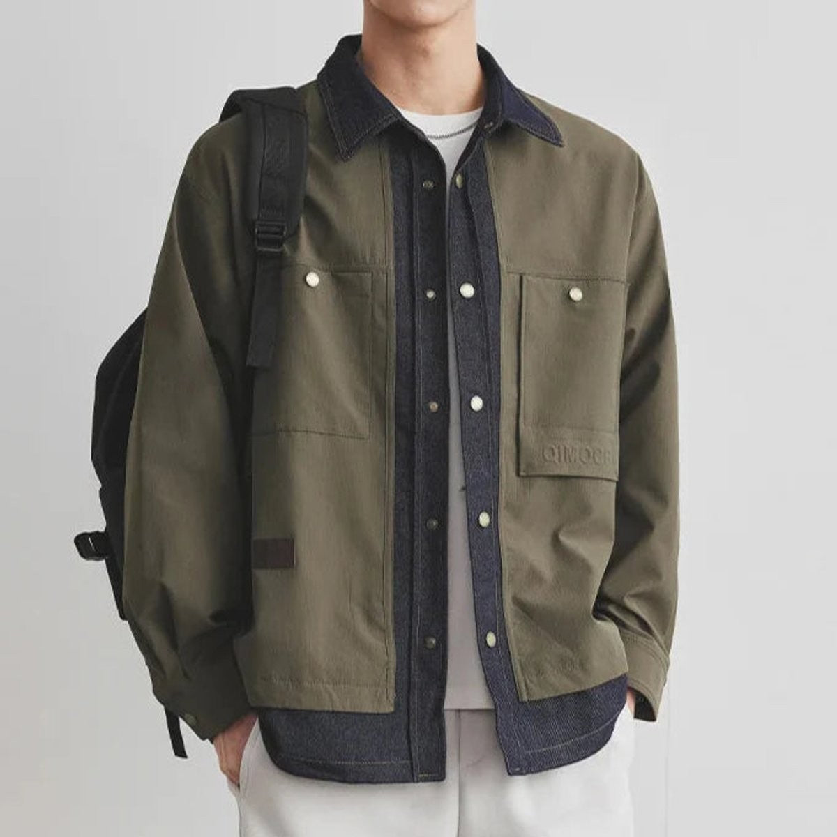 Olive green canvas utility jacket featuring denim collar detail and press-stud pockets