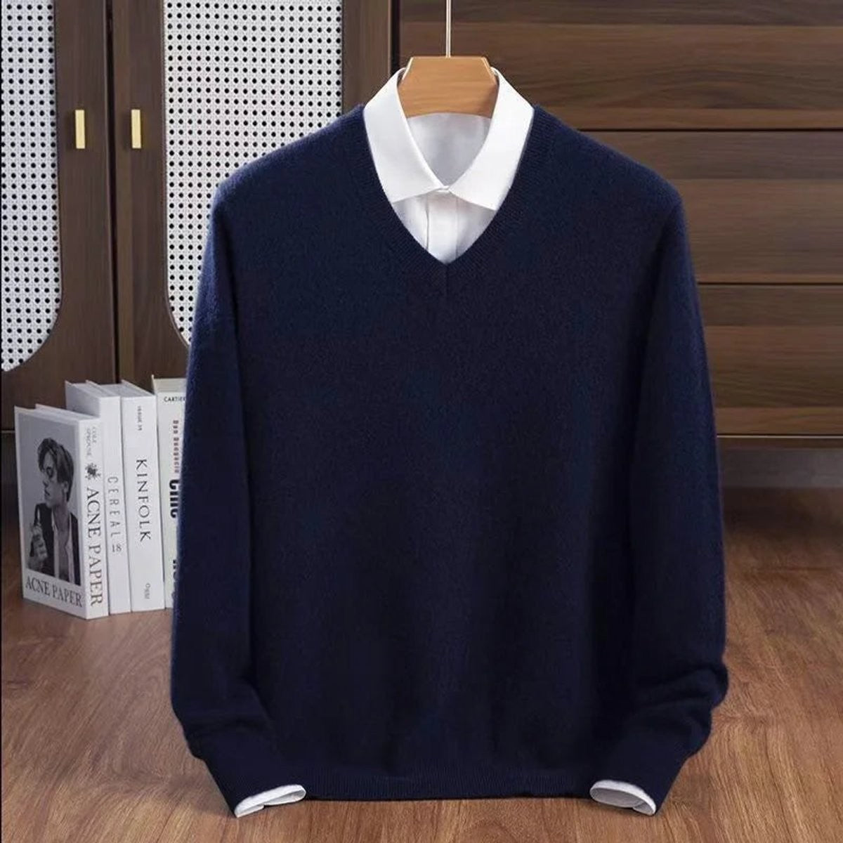 Navy blue V-neck knitted jumper paired with a white shirt underneath