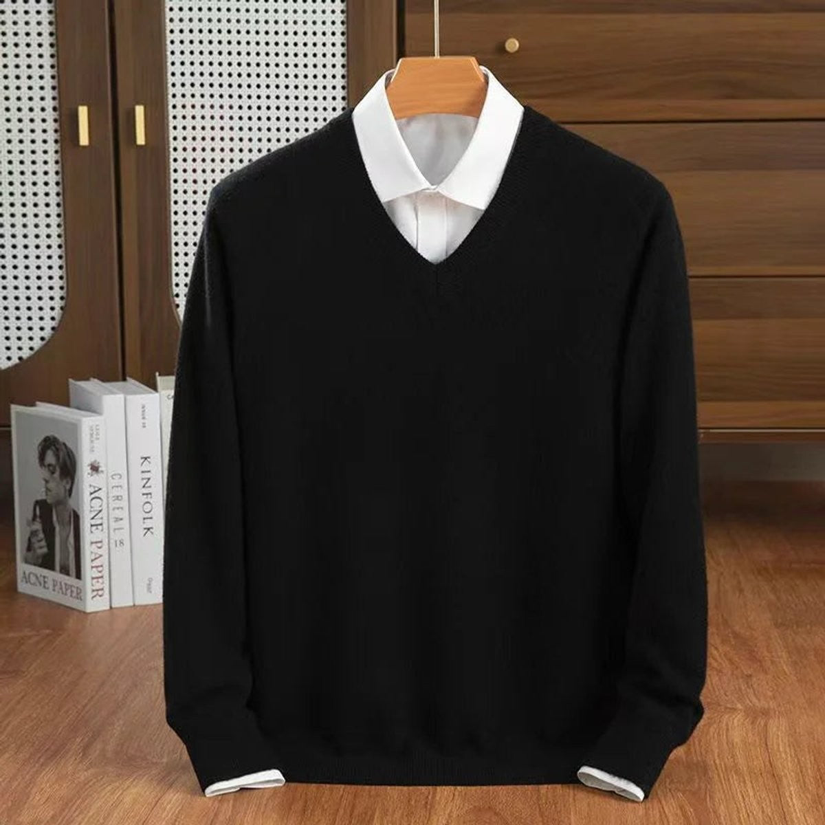 Black V-neck cashmere pullover layered over a crisp white shirt collar