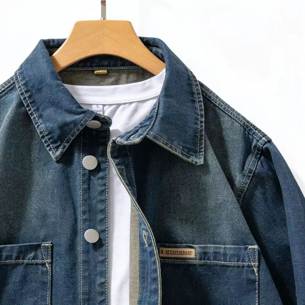 Close-up of denim overshirt collar and branded pocket label