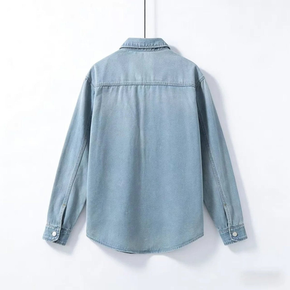 Rear view of pale blue denim overshirt with yoke seam detailing