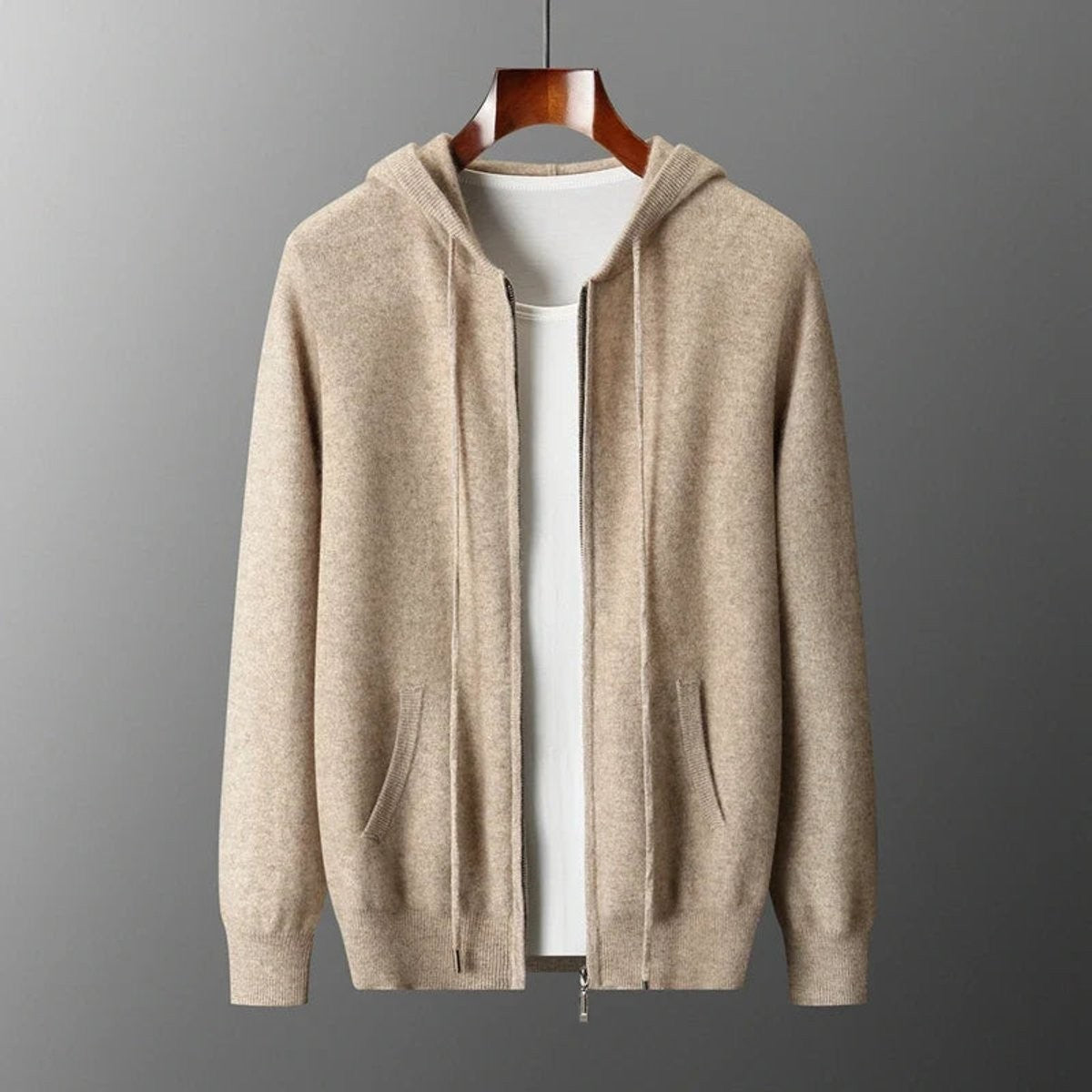 Beige knitted zip-up hoodie with ribbed cuffs displayed on wooden hanger
