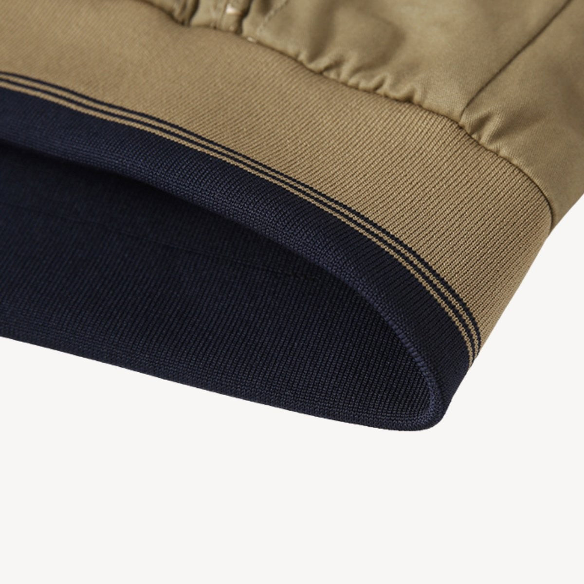 Close-up of navy and beige ribbed hem on reversible bomber jacket