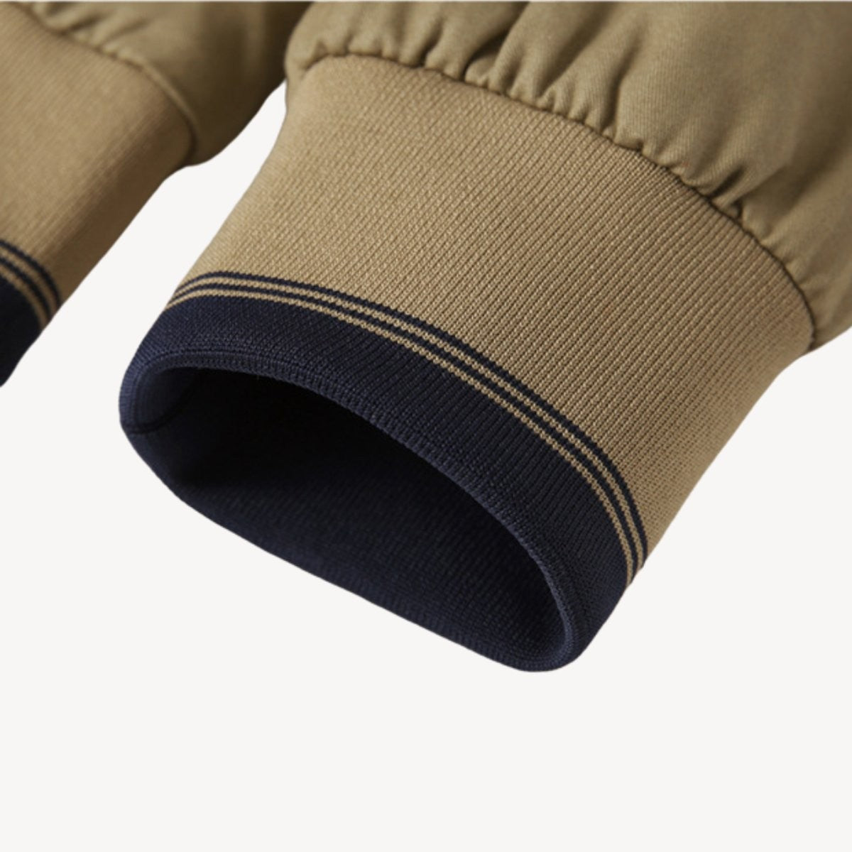 Close-up of ribbed cuffs in navy and beige on bomber jacket sleeve