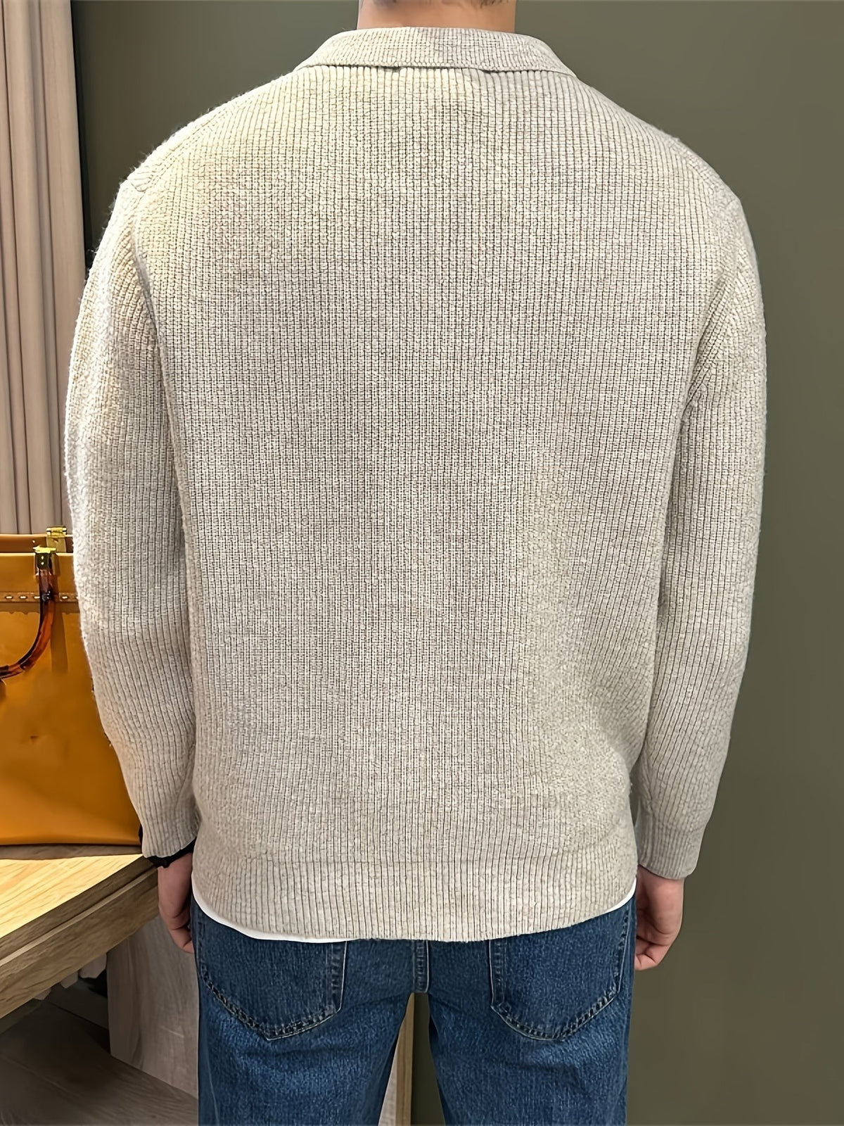 Rear view of beige ribbed knit polo jumper showing collar and hem detail