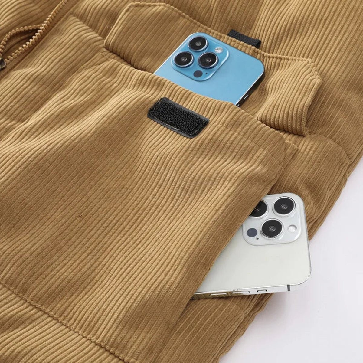 Close-up of corduroy gilet pocket holding two smartphones