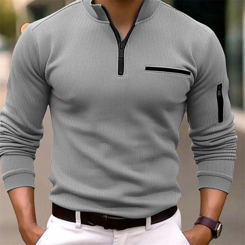 Grey ribbed zip-neck top with sleeve pocket, worn with white trousers