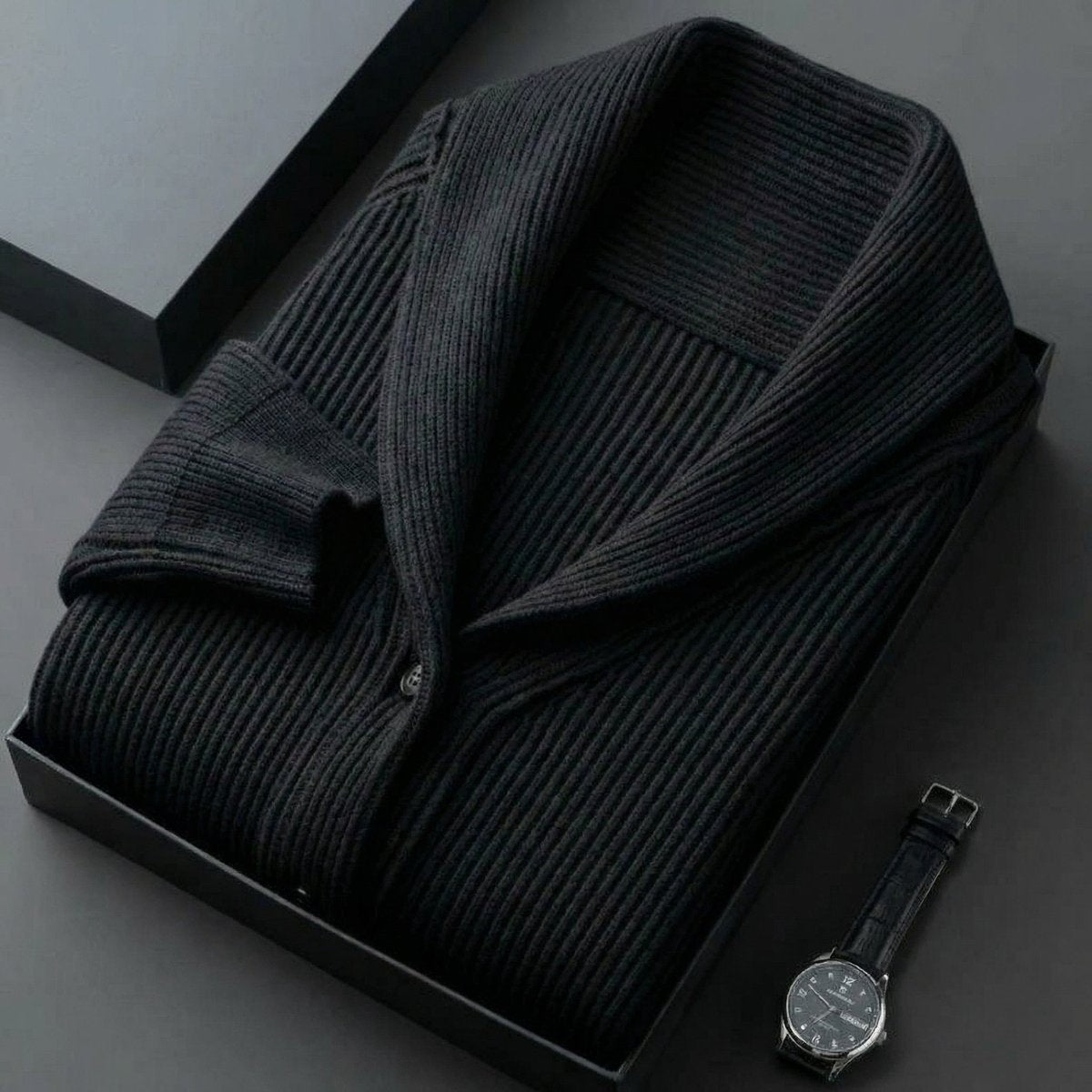 Folded charcoal ribbed shawl-collar cardigan presented alongside a leather watch