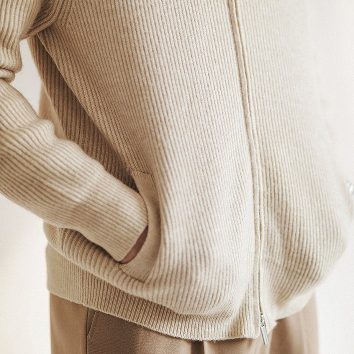 close-up of ribbed-knit cardigan pocket and zip detailing in beige