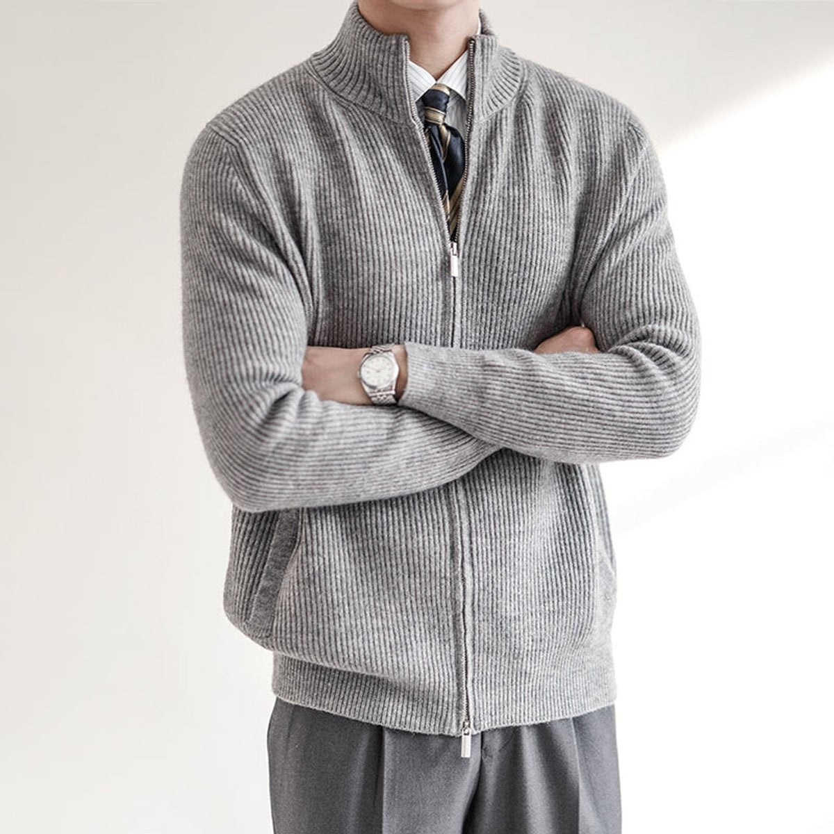 grey ribbed-knit zip-up cardigan jumper with stand collar, arms folded