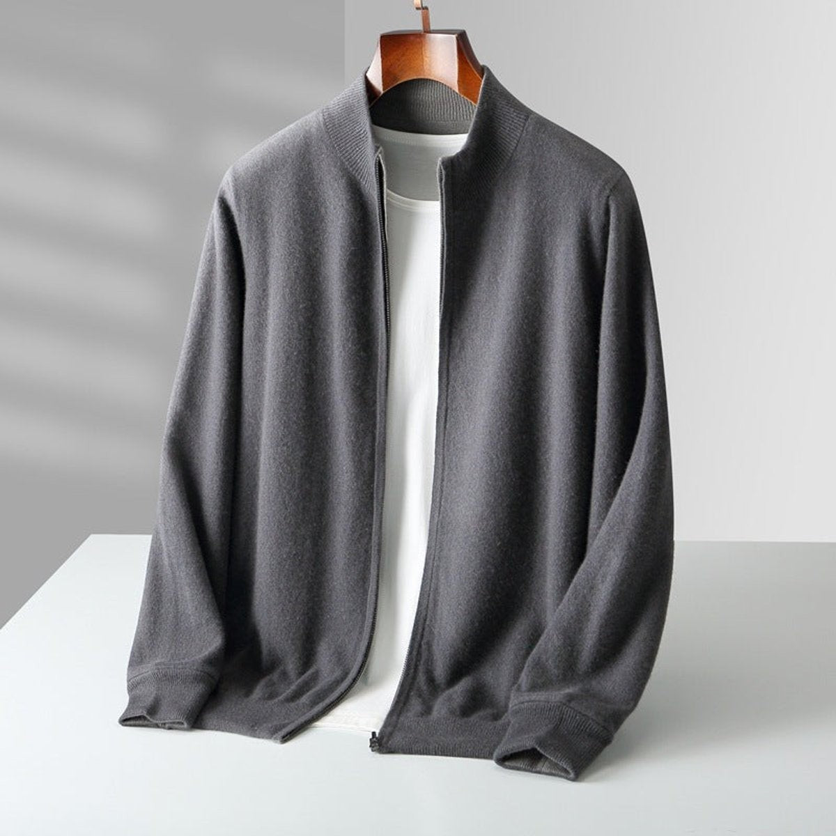 Charcoal grey knitted full-zip cardigan displayed on wooden hanger