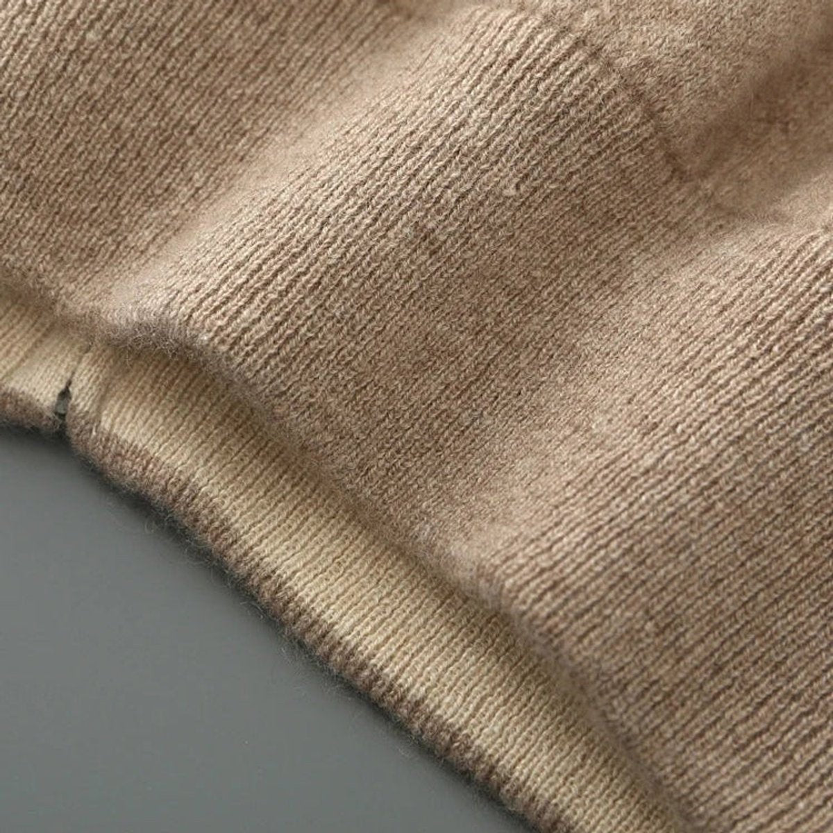 Close-up of ribbed cuff and hem on beige knitted cardigan