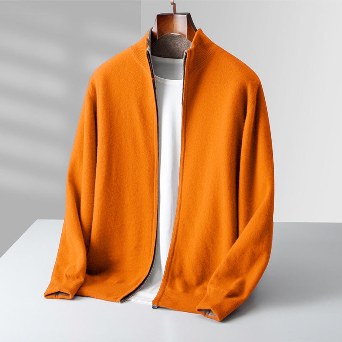 Orange knitted full-zip cardigan with contrast collar on hanger