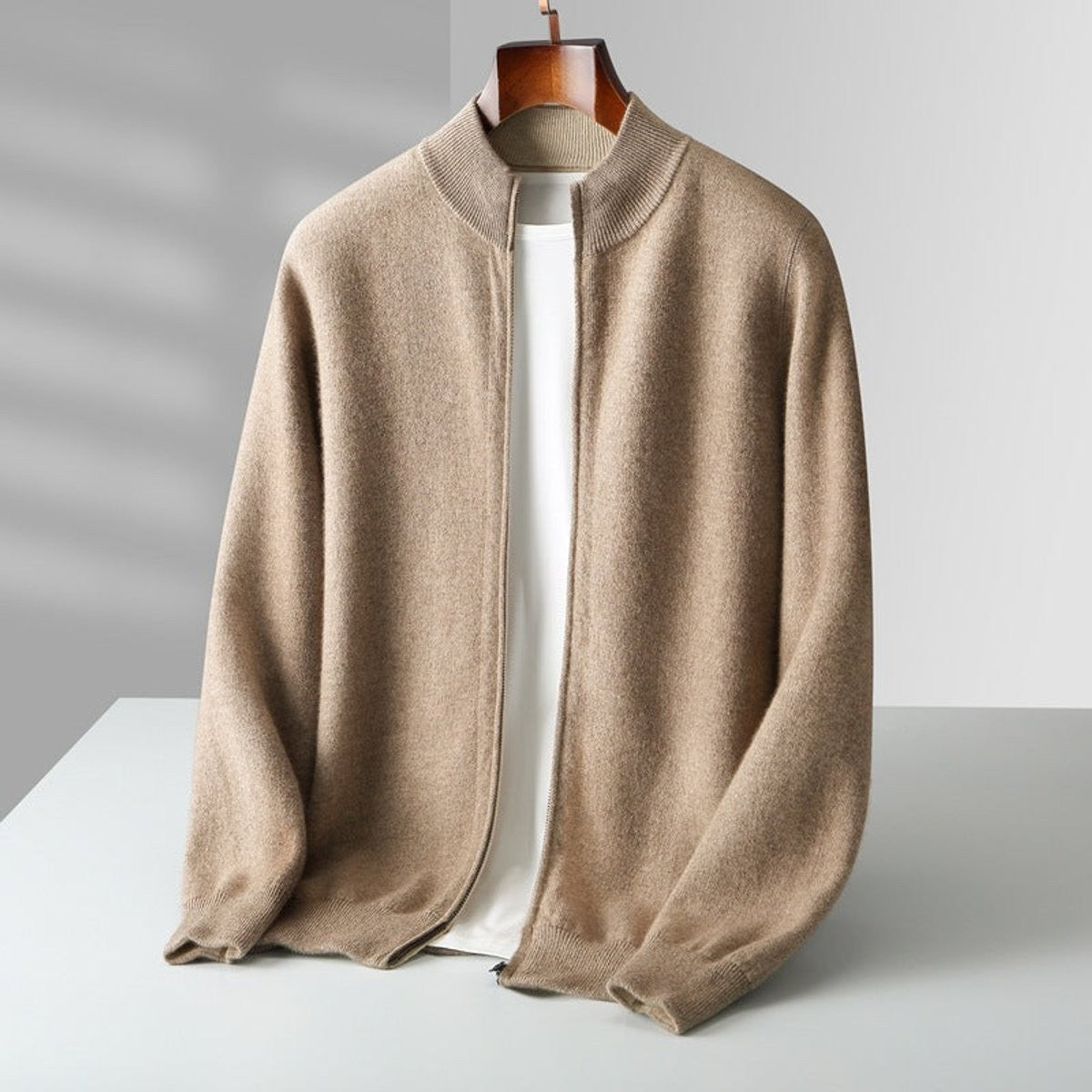 Camel-coloured knitted cardigan with ribbed collar on wooden hanger