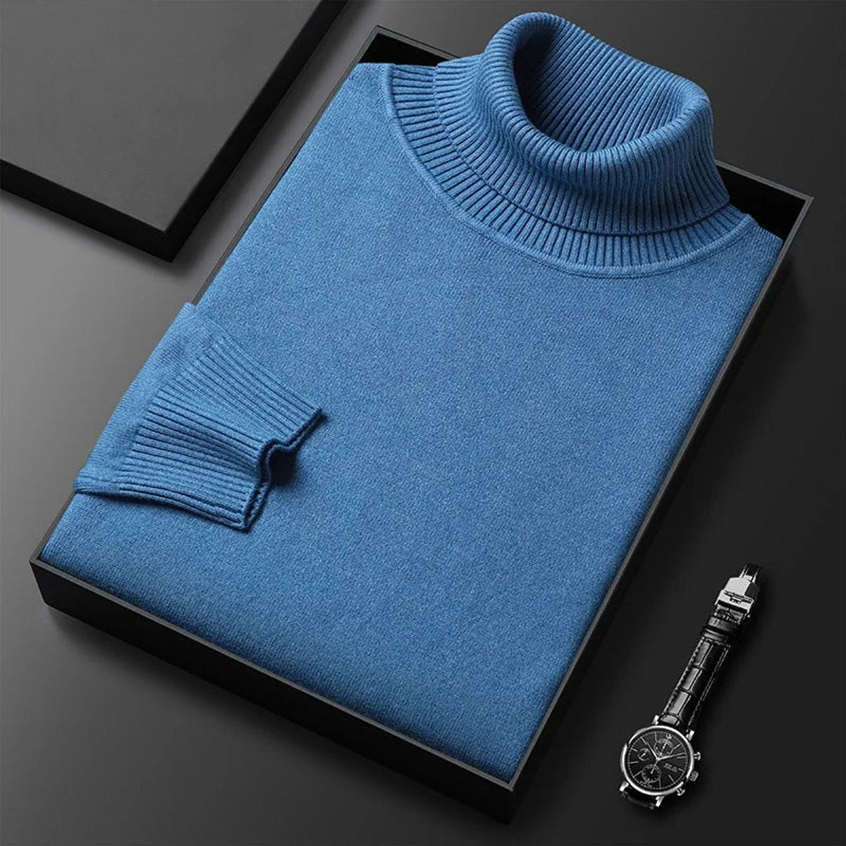 Folded blue turtleneck jumper displaying ribbed knit cuff detail
