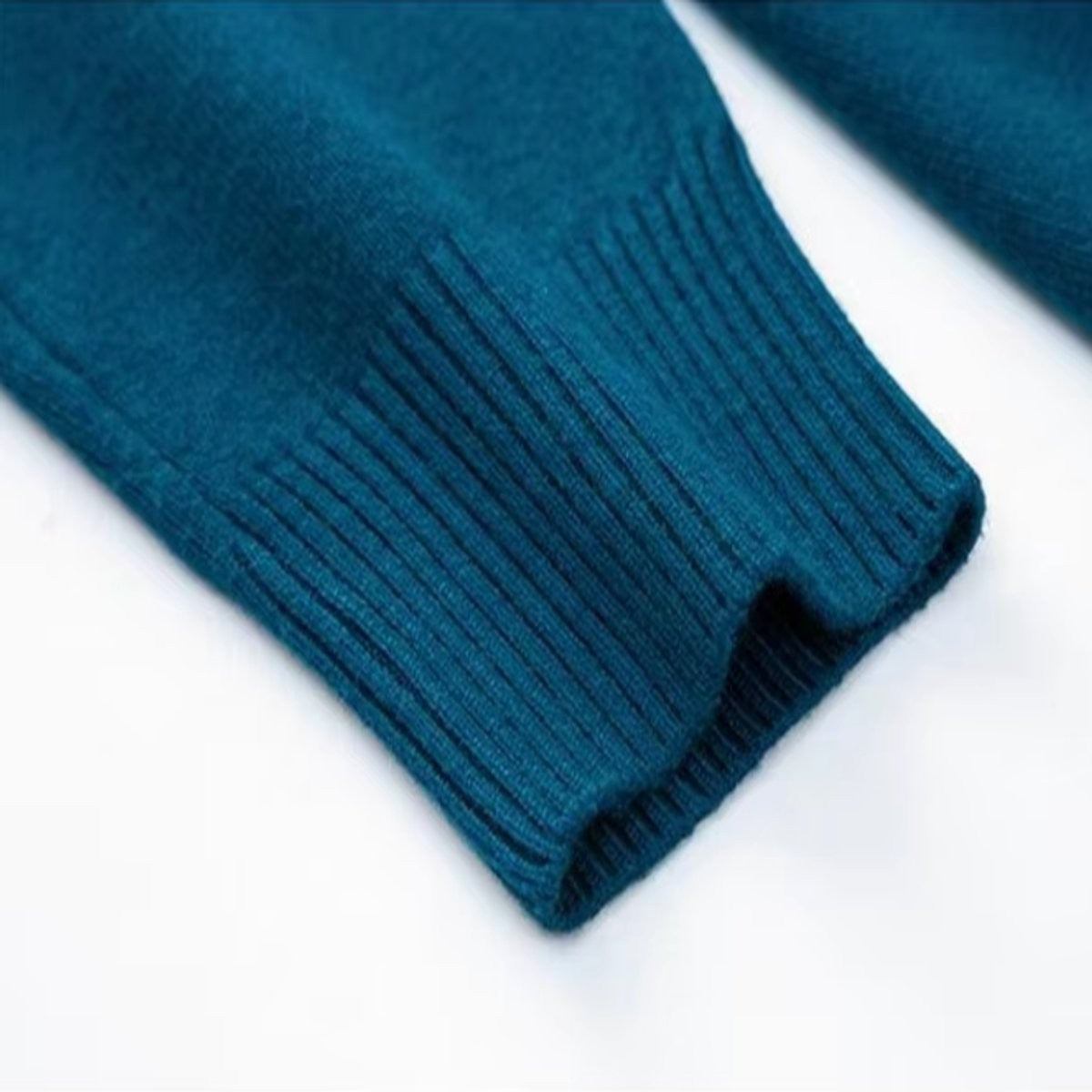 Close-up of teal ribbed cuff on knitted turtleneck jumper