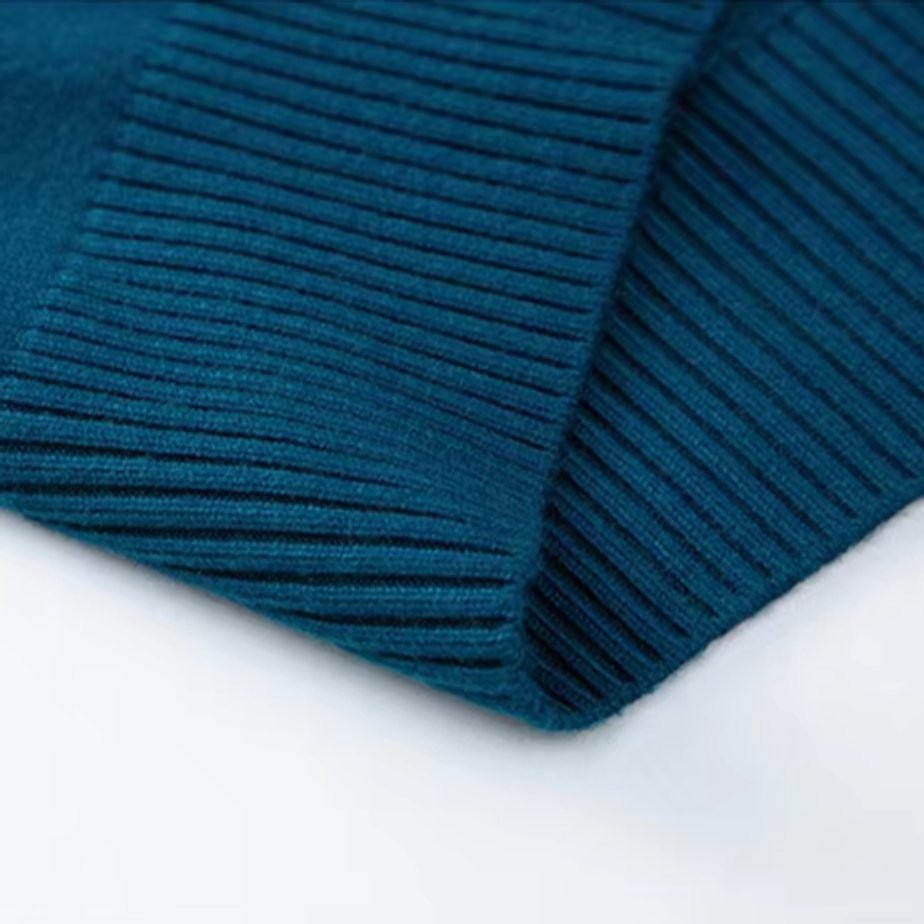 Macro shot of teal ribbed knit fabric on jumper sleeve