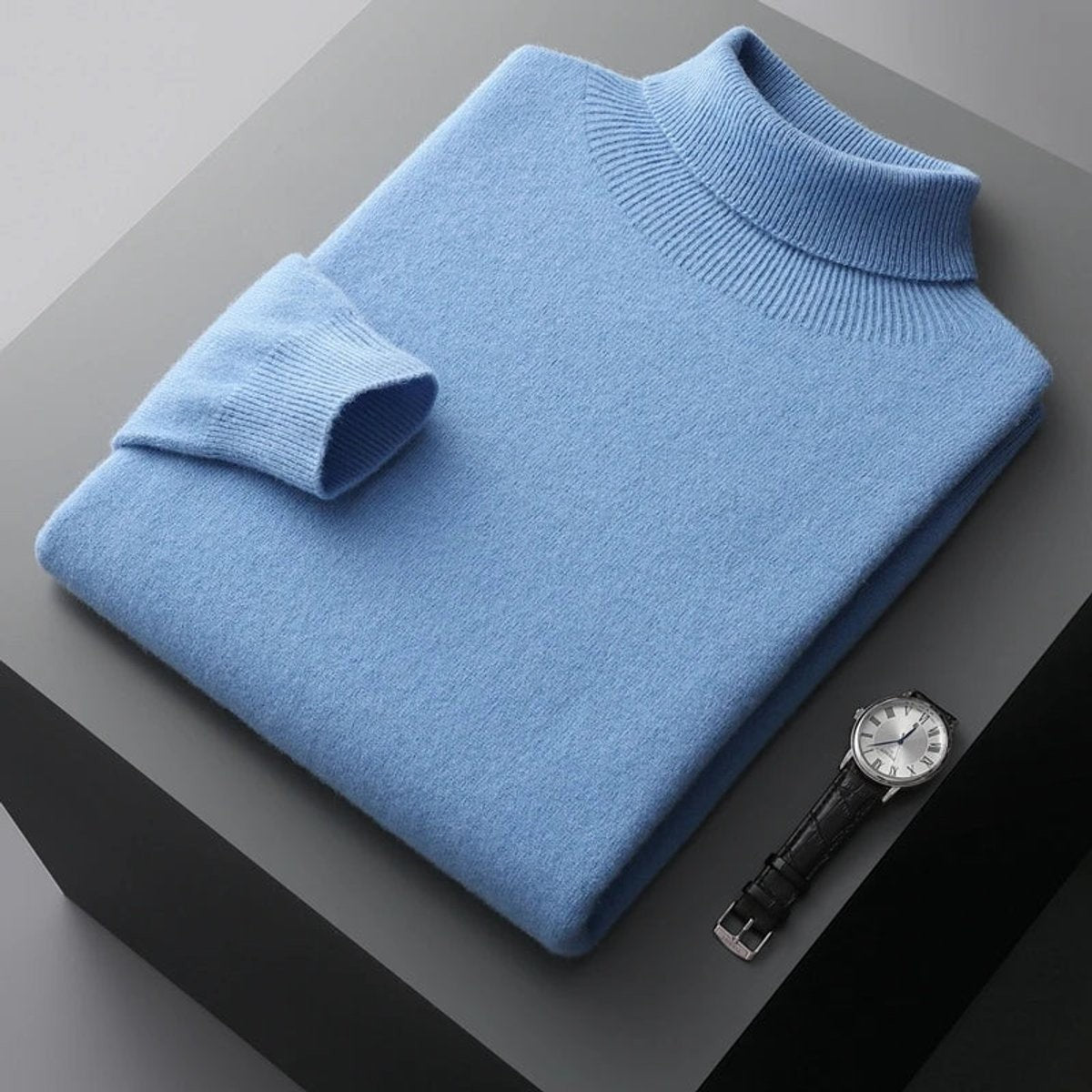 Sky blue merino wool turtleneck jumper folded neatly beside a wristwatch
