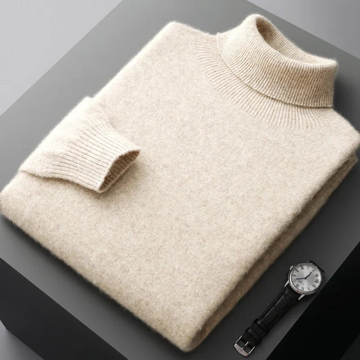 Cream merino wool turtleneck jumper folded neatly next to a wristwatch