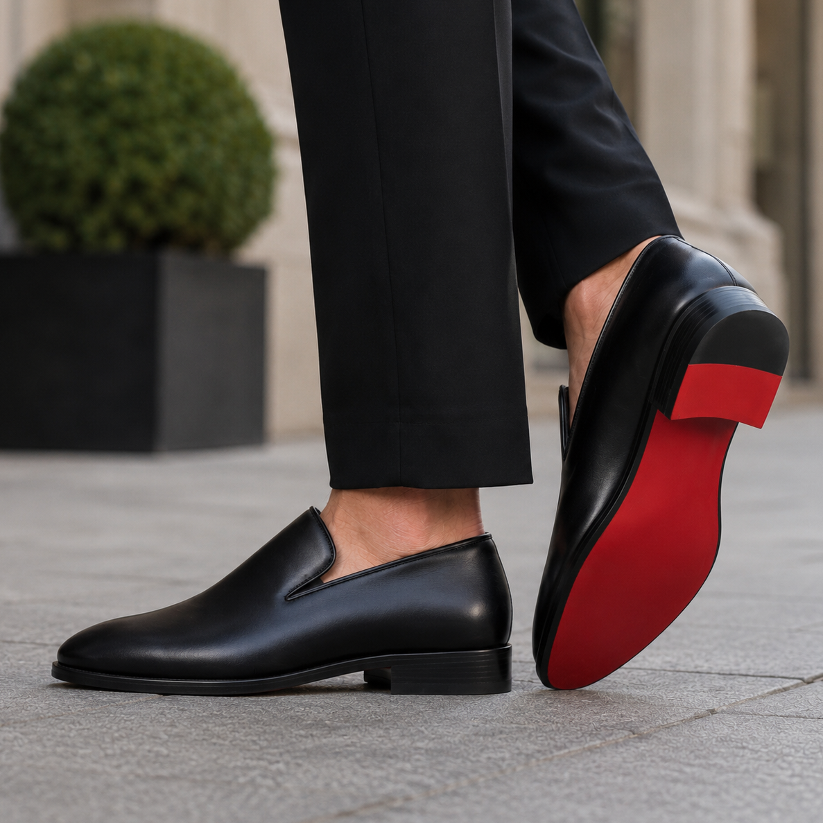Man walking outdoors in black leather loafers with red sole detail