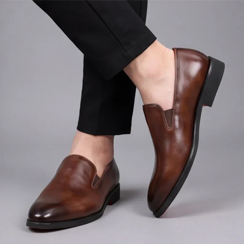 Man wearing brown leather loafers styled with tailored black trousers